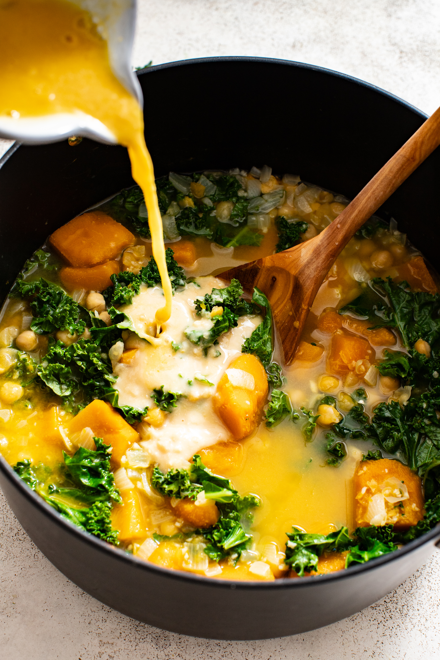 Pouring a miso paste and water mixture into a pot of soup