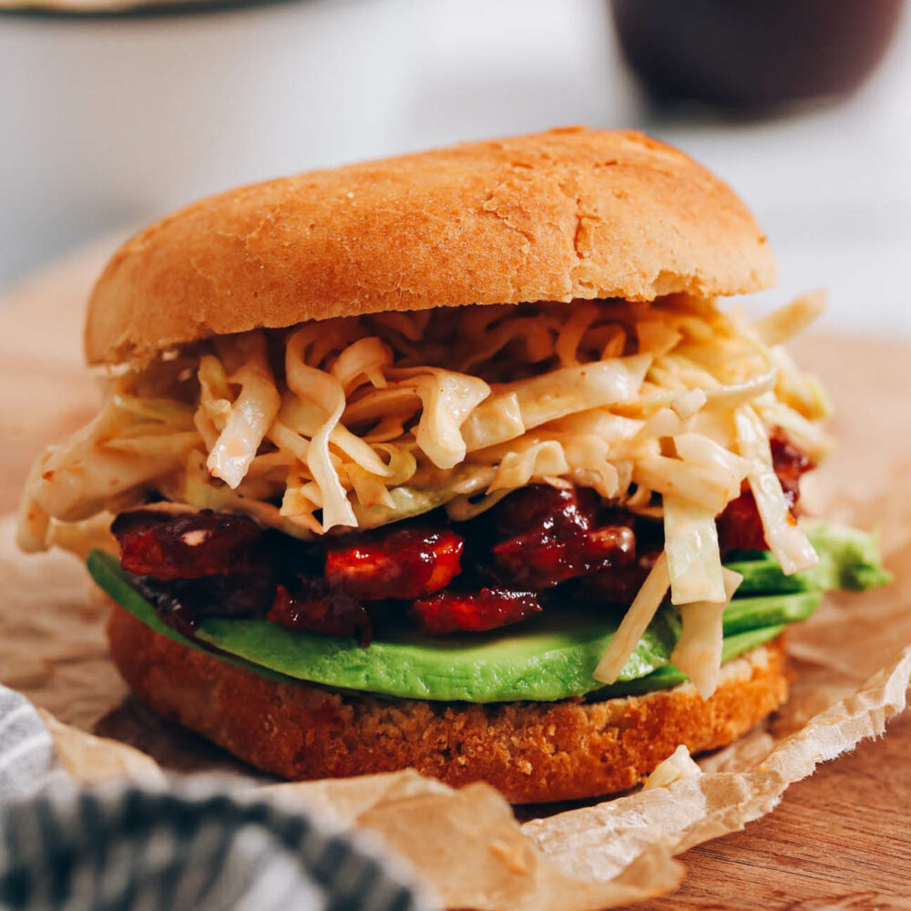 BBQ tempeh sandwich resting on a cutting board