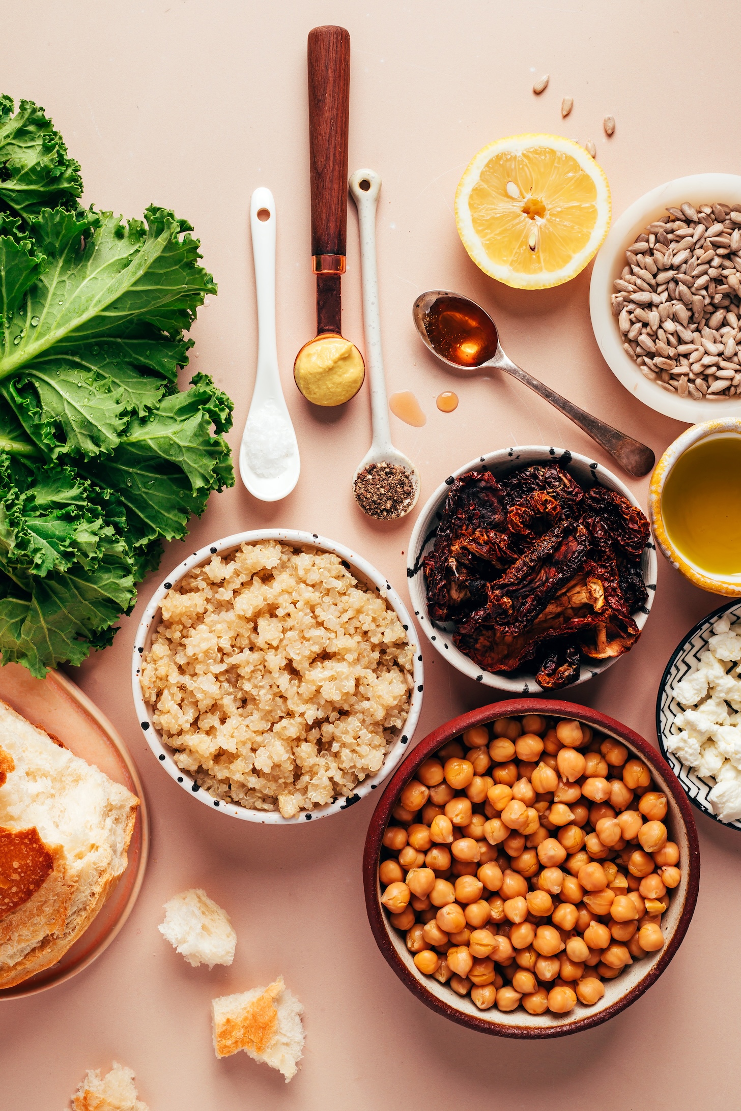 Kale, bread, quinoa, chickpeas, sun-dried tomatoes, goat cheese, olive oil, sunflower seeds, lemon, maple syrup, black pepper, mustard, and salt