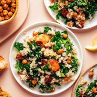 Overhead photo of plates of our Lemony Quinoa Kale Salad next to a bowl of crispy chickpeas