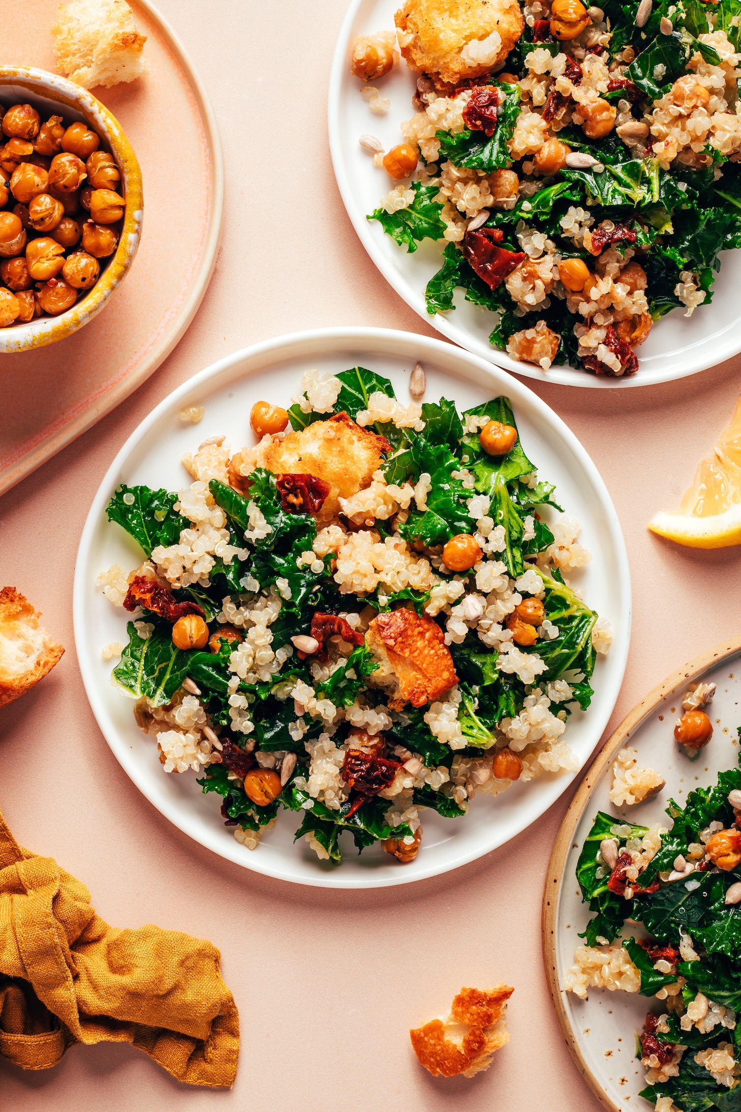 Plates of our Lemony Quinoa Kale Salad recipe next to a bowl of crispy chickpeas