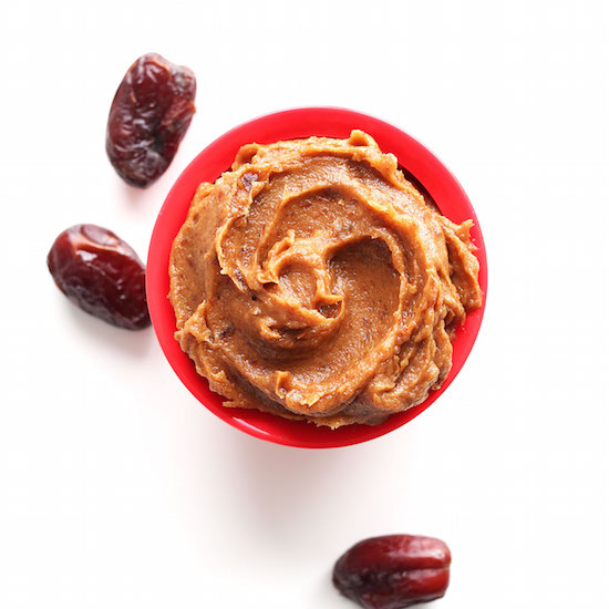 Medjool dates beside a bowl of homemade date caramel
