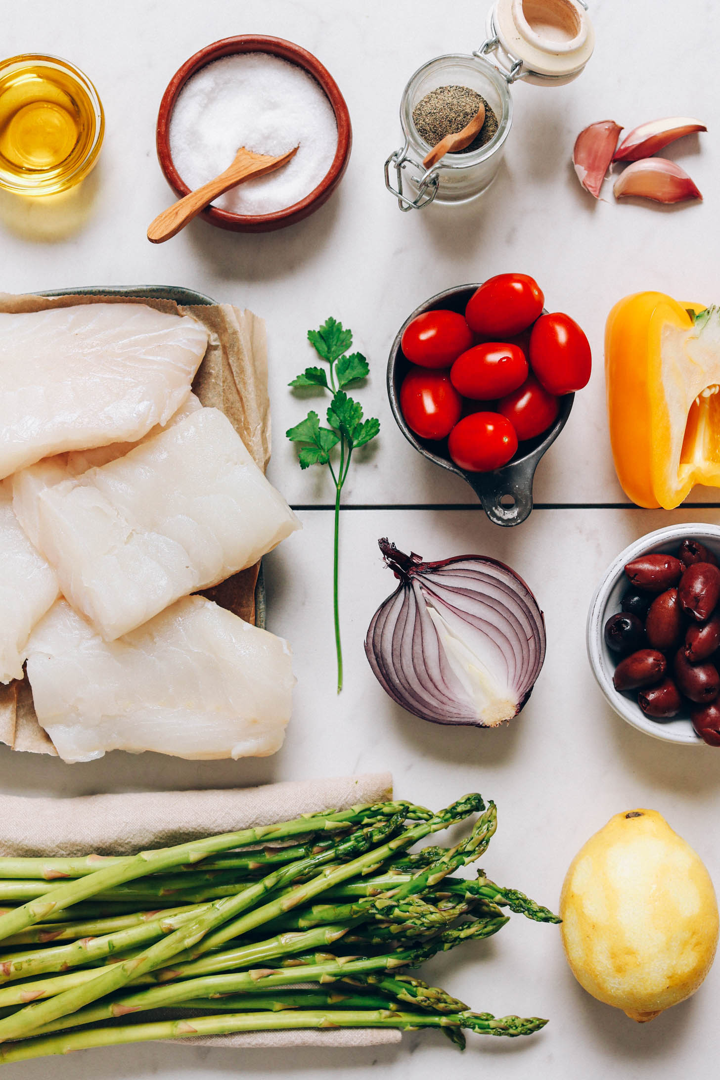 Olive oil, salt, pepper, garlic, bell pepper, tomatoes, parsley, red onion, olives, lemon, and asparagus