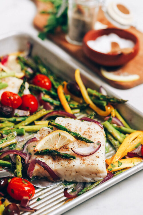 Baking sheet with baked cod and vegetables