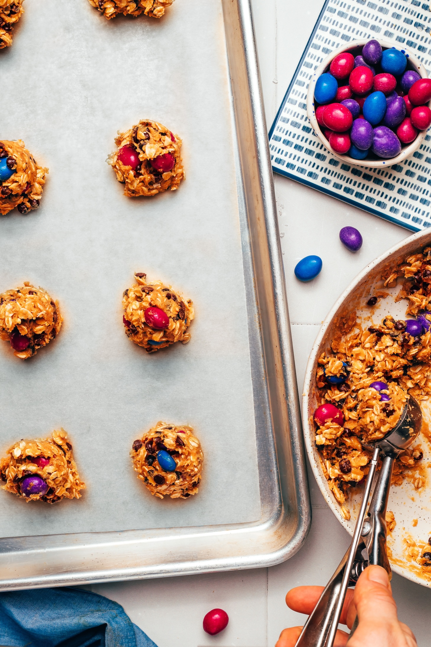 Using a cookie scoop to scoop cookie dough onto a baking sheet