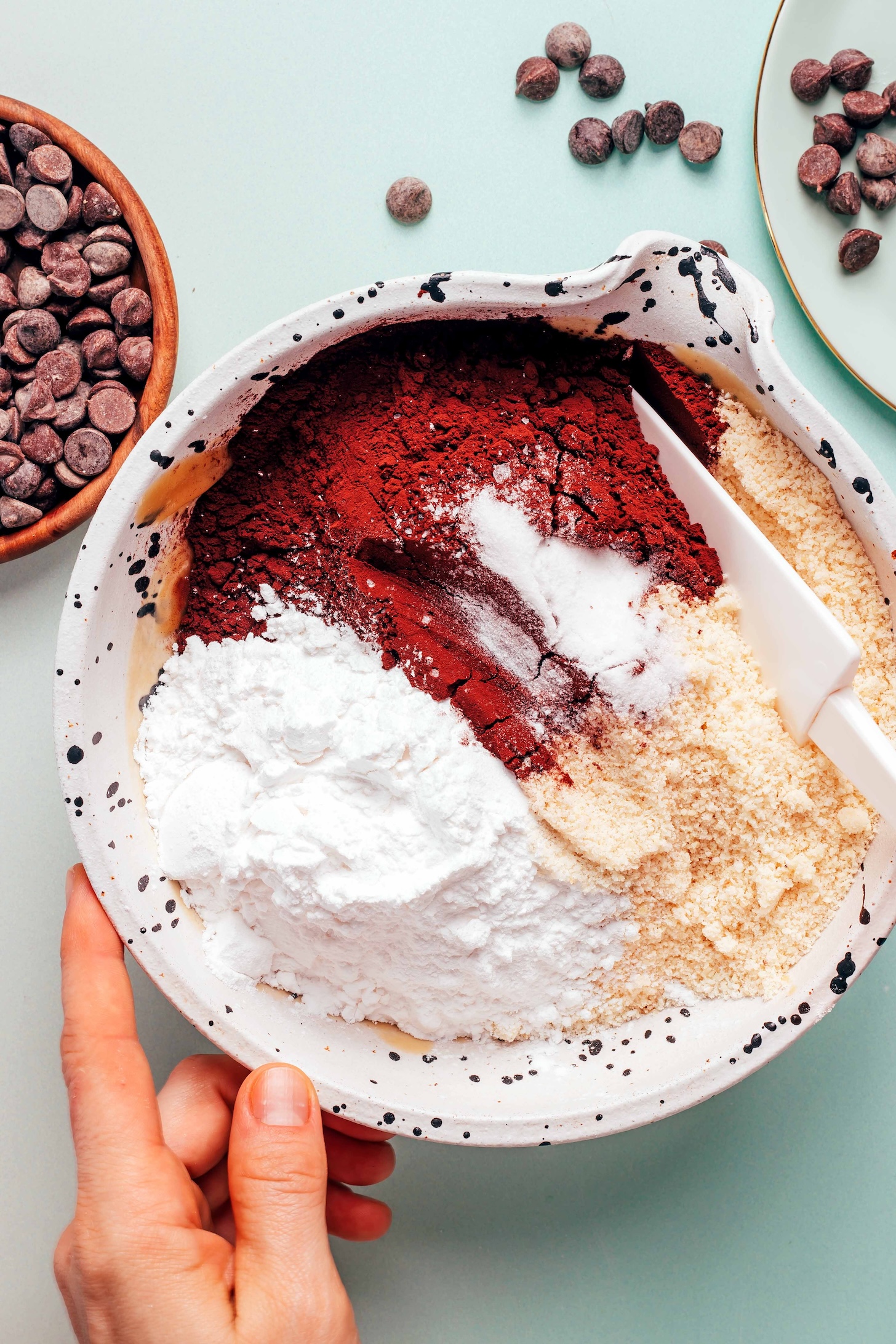Bowl of dry ingredients including cocoa powder, almond flour, tapioca starch, and baking soda