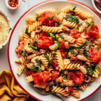 Overhead shot of a serving dish filled with garlicky cherry tomato and white bean pasta