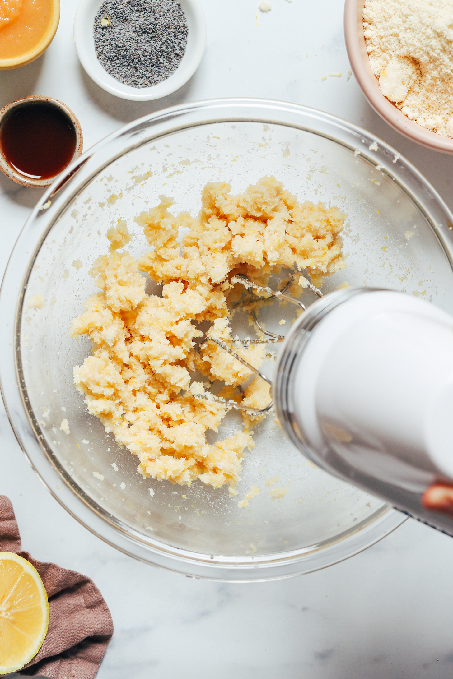 Using a hand mixer to cream the sugar and butter with lemon zest