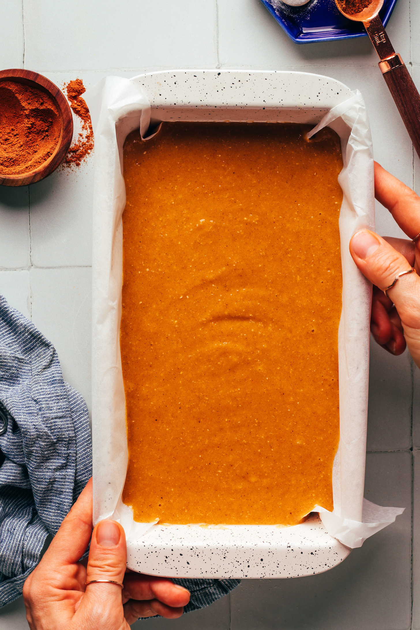 Loaf pan filled with pumpkin bread batter