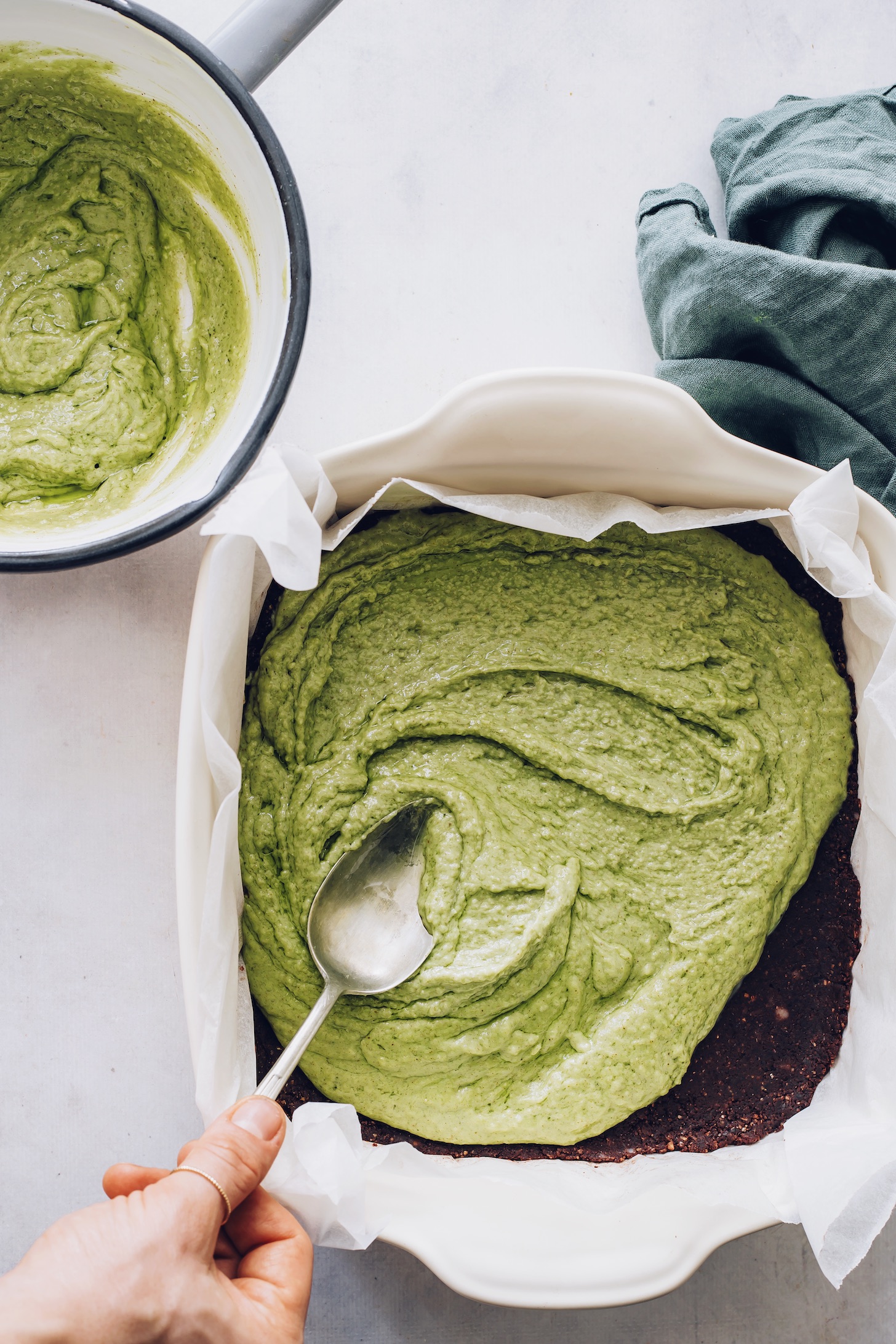 Spreading the mint coconut filling over the brownie layer