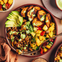 Overhead view of a Jerk Tofu and Roasted Plantain Bowl with sliced avocado