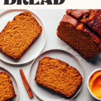 Plates with slices of pumpkin bread next to a partial loaf with text above that says best gluten-free pumpkin bread made in 1 bowl