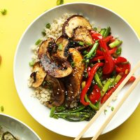 Chopsticks resting on a bowl of our flavorful Portobello Mushroom Stir Fry
