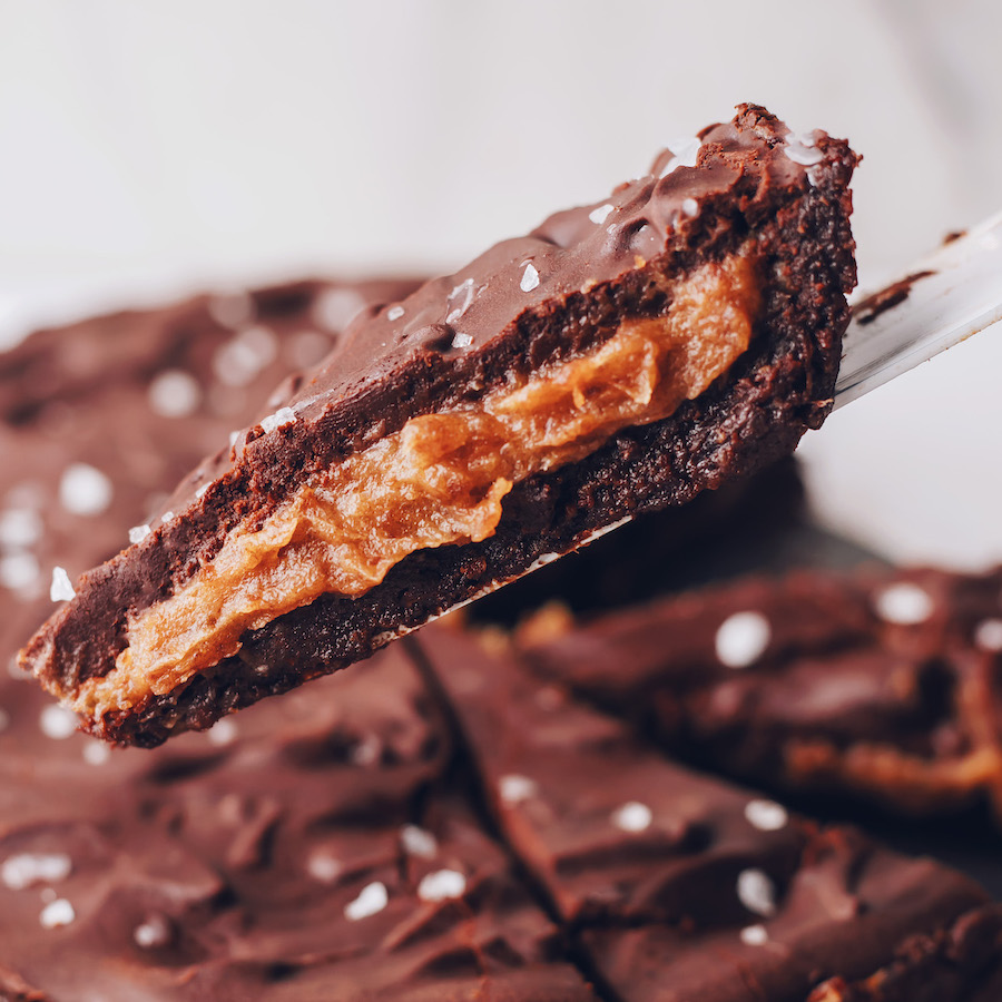 Slice of our salted caramel chocolate ganache tart on a pie cutter