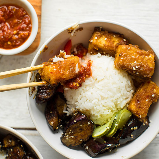 Using chopsticks to pick up a piece of Sesame Tofu