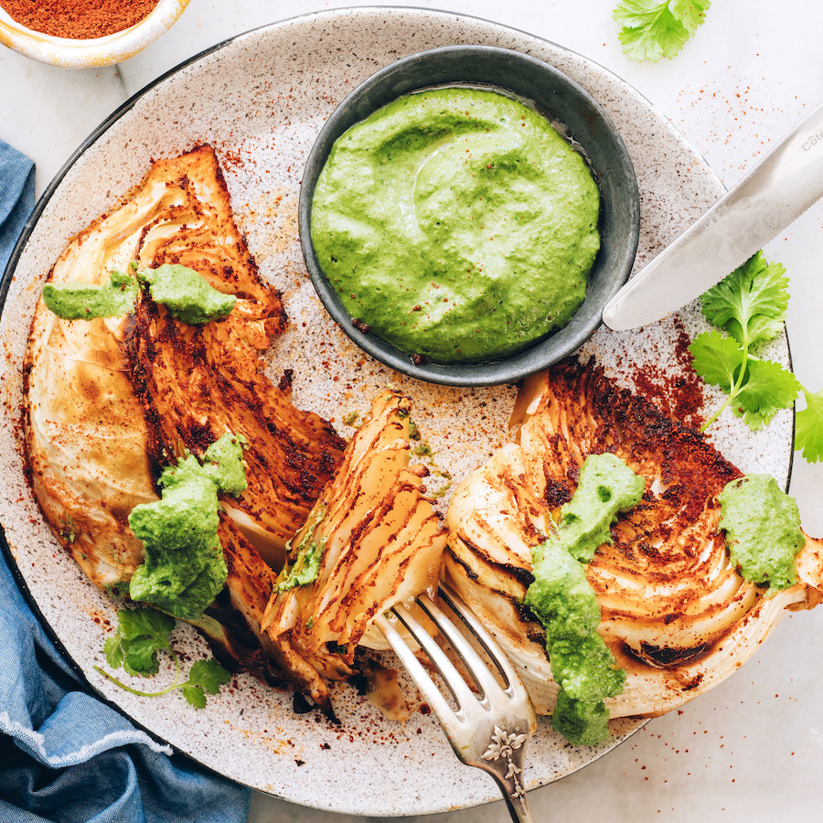Fork above a plate of roasted cabbage wedges