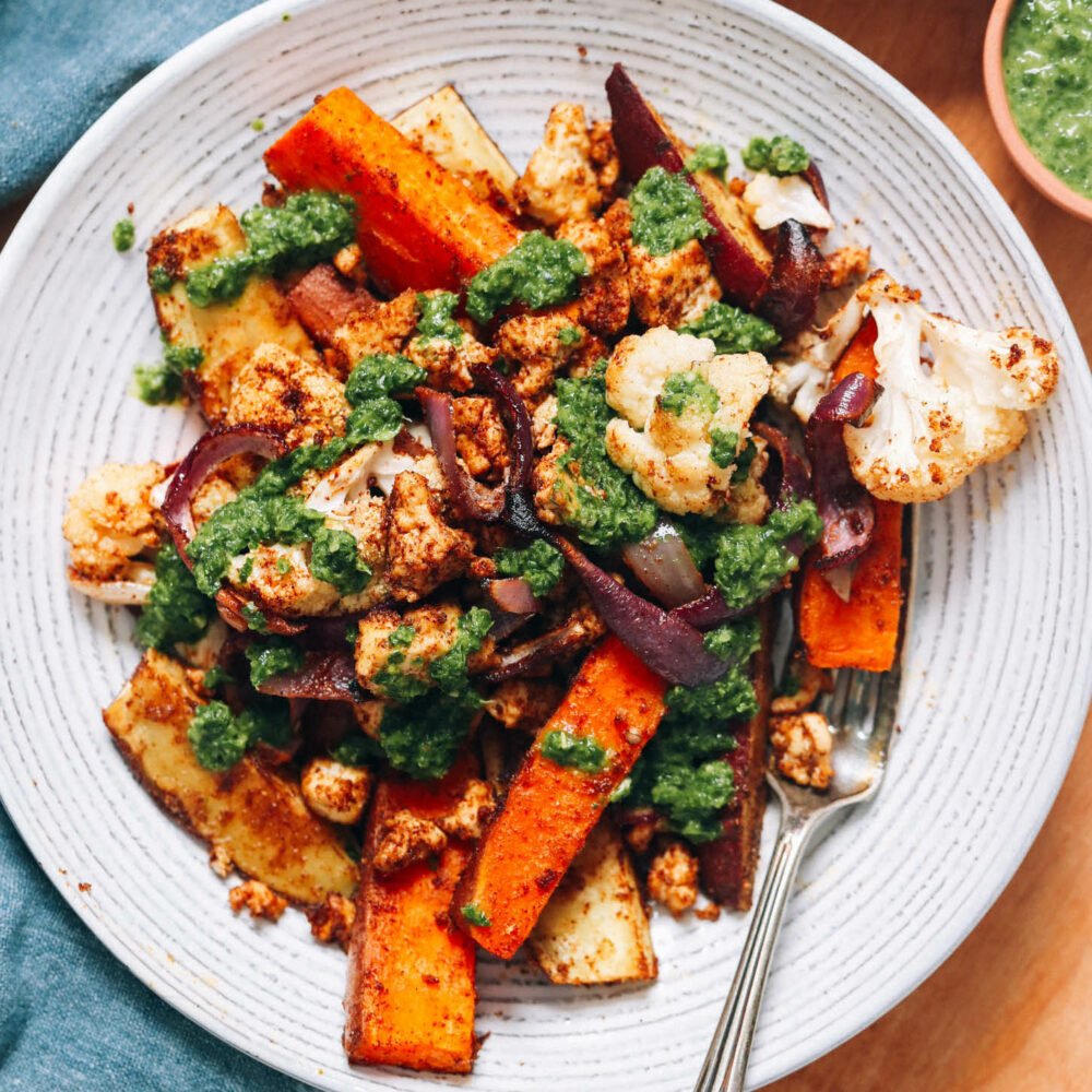 Roasted sweet potatoes, tofu, and cauliflower topped with green chutney