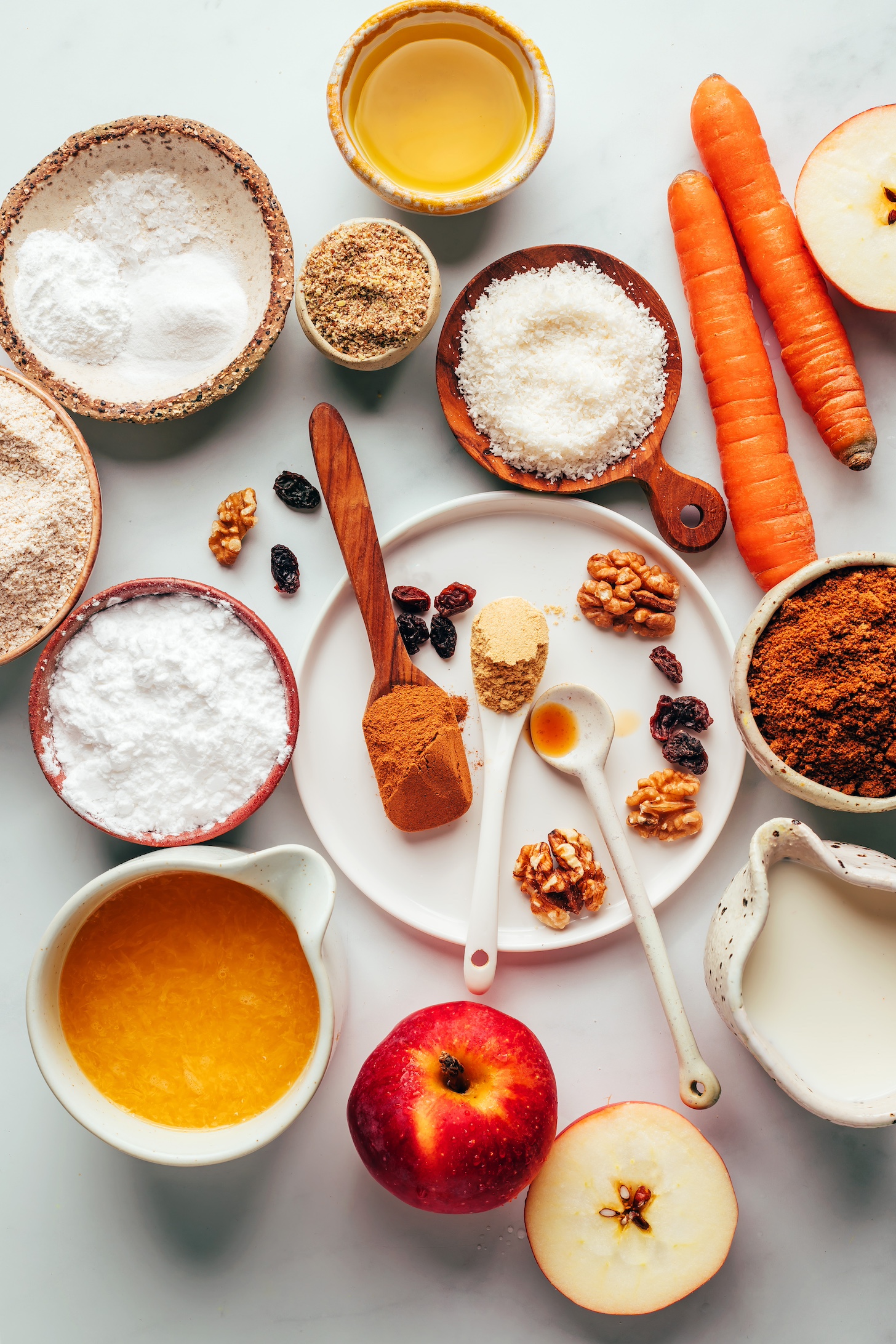 Carrots, apples, coconut sugar, almond milk, orange juice, walnuts, raisins, spices, flours, flaxseed meal, coconut, and avocado oil