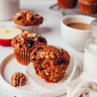 Plates of our vegan gluten-free morning glory muffins next to mugs of coffee