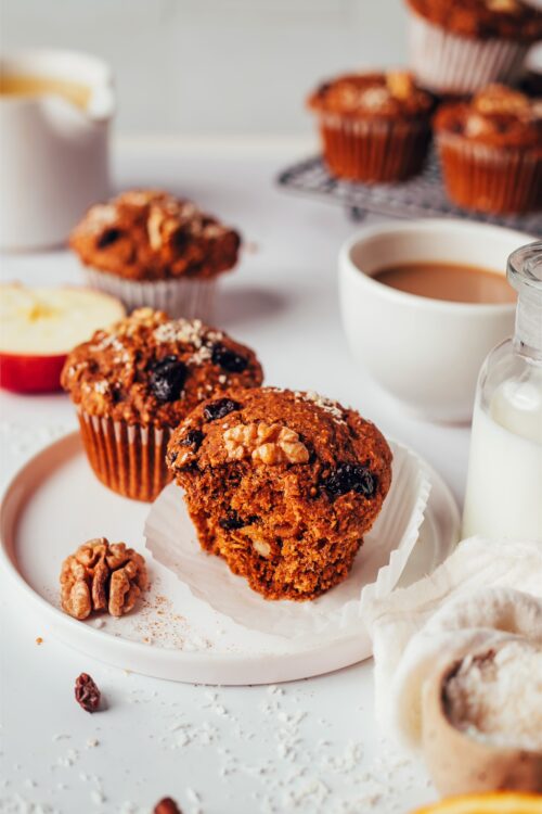 Plates of our vegan gluten-free morning glory muffins next to mugs of coffee