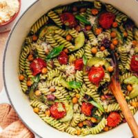 Dutch oven filled with our vegan zucchini pesto pasta with cherry tomatoes and chickpeas